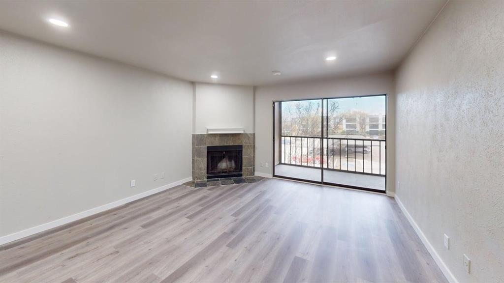 11460 Audelia Road, Unit 284 Dallas, TX 75243 - Photo 5 of 15 an empty room with wooden floor fireplace and windows