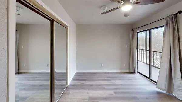 an empty room with closet and a chandelier fan