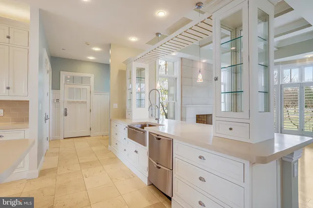 a large white kitchen with a large window