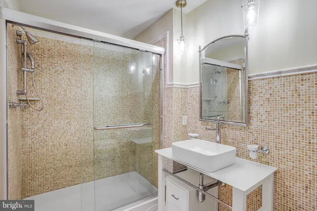 a bathroom with a sink mirror and a shower