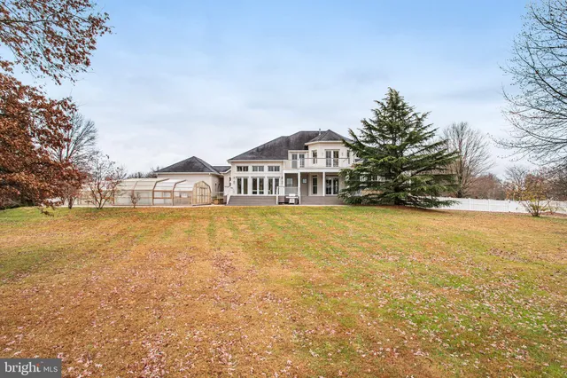 a view of a large pool with lawn chairs under an umbrella