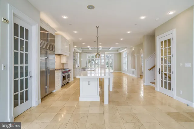 a open kitchen with white cabinets and stainless steel appliances