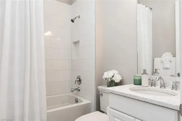 a bathroom with a sink vanity granite tub and shower