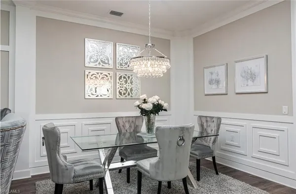 a dining room with furniture a chandelier and window