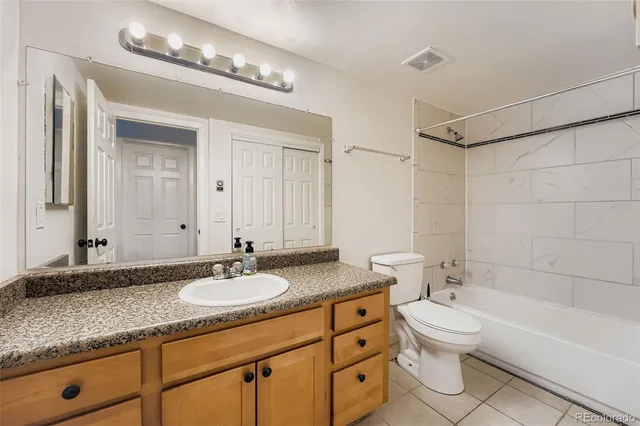 a bathroom with a granite countertop double vanity sink a mirror and a bathtub