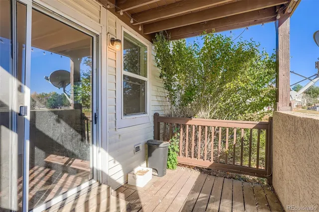 a view of a balcony with wooden floor and iron stairs
