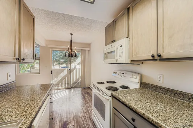 a kitchen with granite countertop a stove a sink and dishwasher