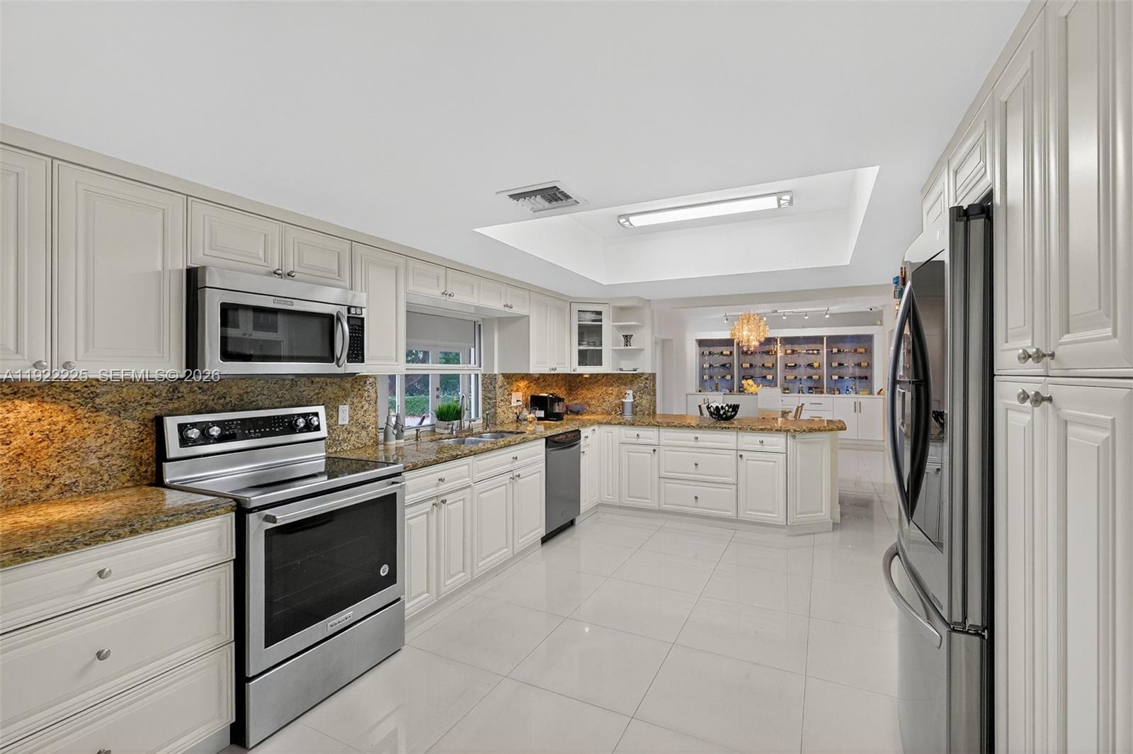 9261 Southwest 88th Street Miami, FL 33173 - Photo 14 of 55 a kitchen with white cabinets and stainless steel appliances