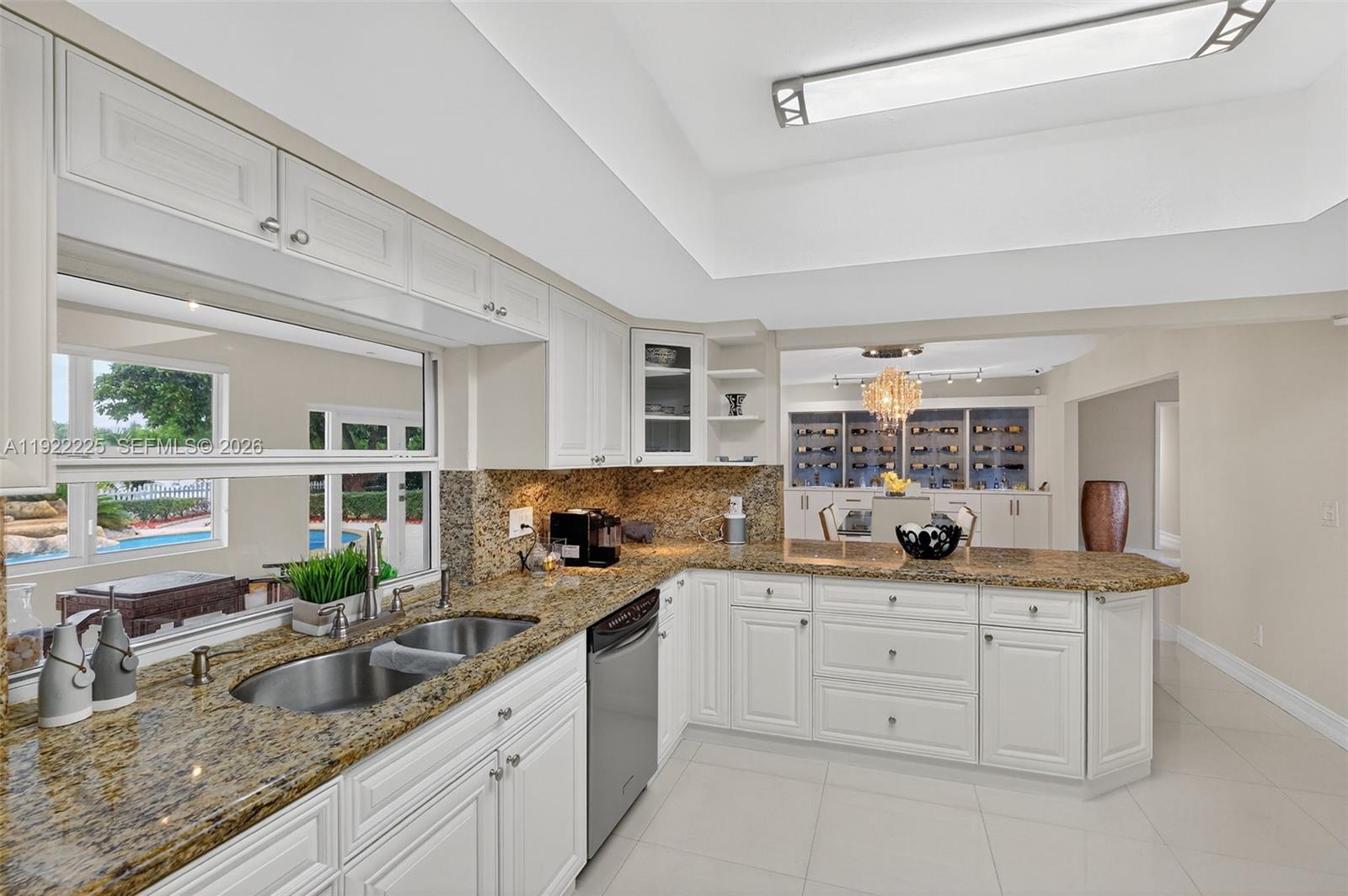 9261 Southwest 88th Street Miami, FL 33173 - Photo 15 of 55 a kitchen with granite countertop a sink stainless steel appliances white cabinets and window