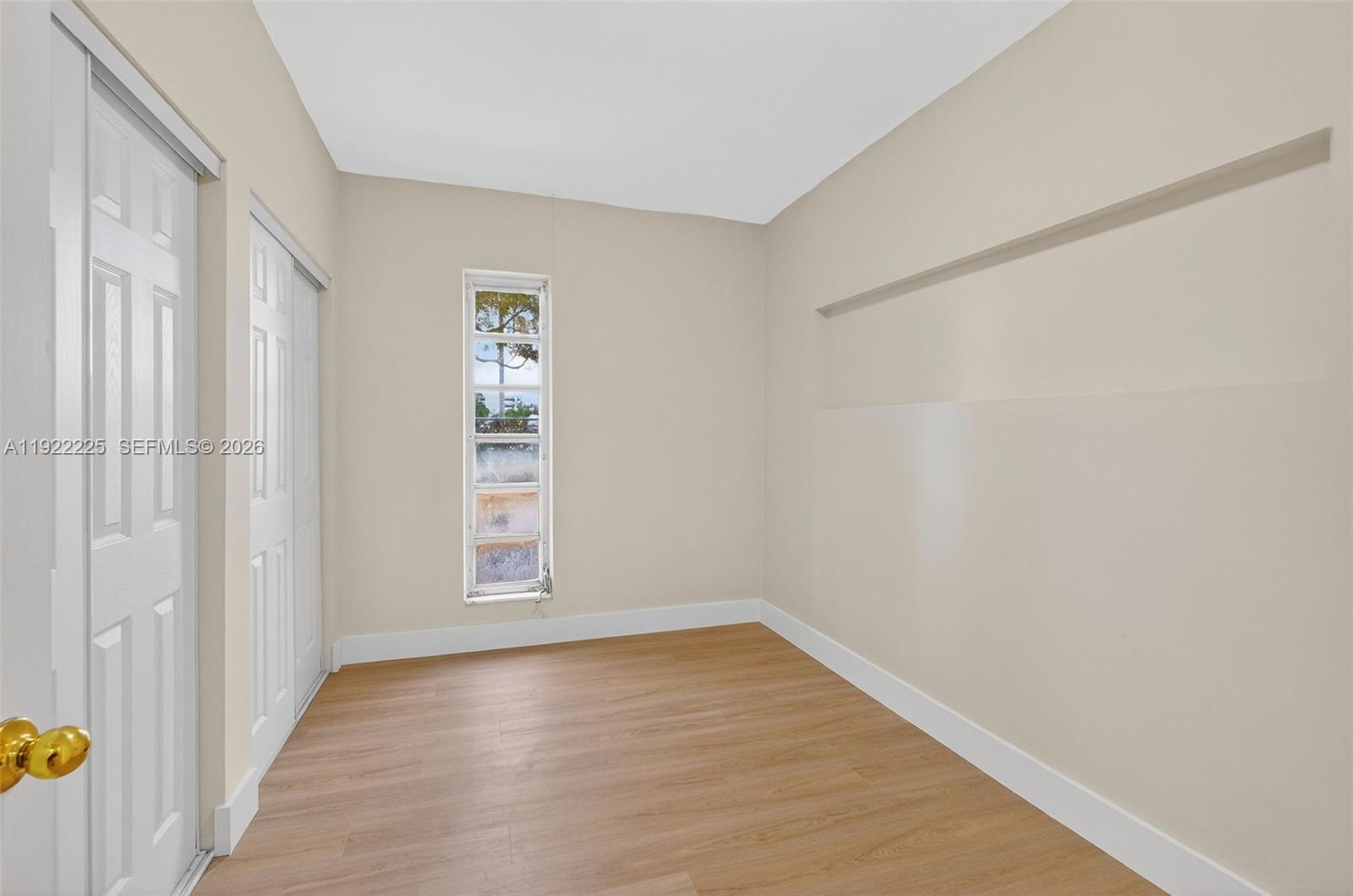 9261 Southwest 88th Street Miami, FL 33173 - Photo 23 of 55 a view of an empty room with wooden floor and a window