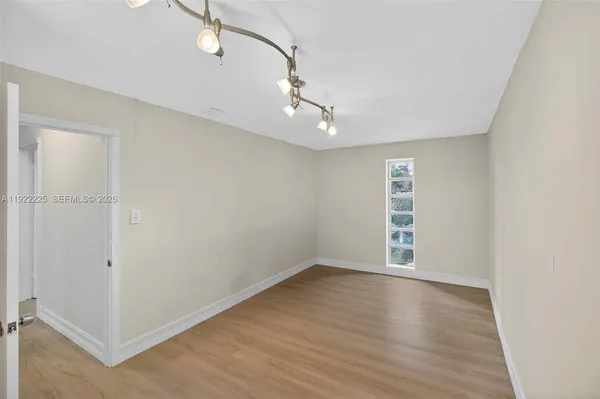 a spacious bedroom with a bed and wooden floor