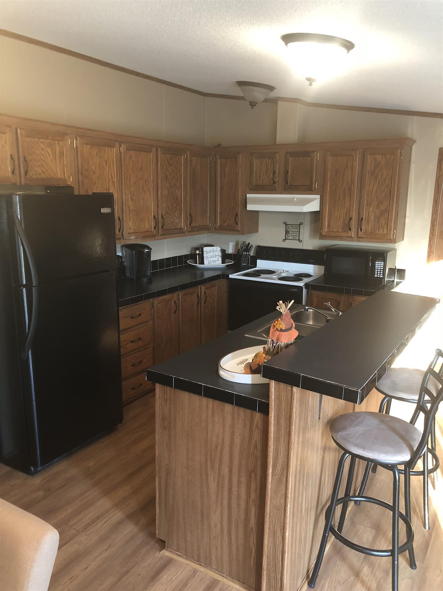 3692 Gwynn Road Lebanon, TN 37090 - Photo 2 of 10 a kitchen with a refrigerator a stove a sink and a cabinets