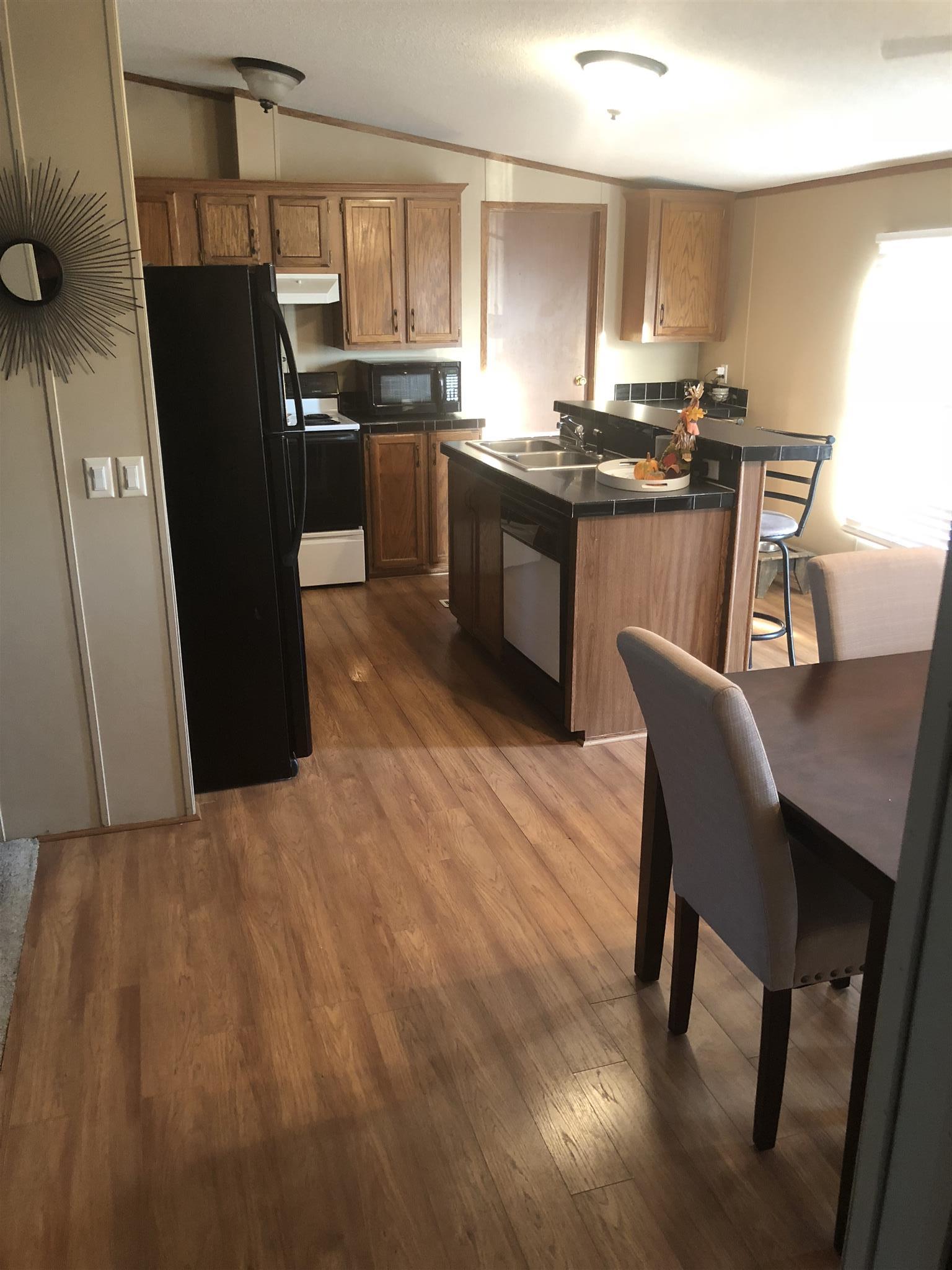 3692 Gwynn Road Lebanon, TN 37090 - Photo 3 of 10 a kitchen with stainless steel appliances granite countertop a refrigerator a sink a stove a dining table and chairs