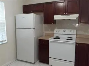 a kitchen with granite countertop a sink cabinets and wooden floor