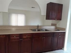 4100 Riverside Drive, Unit 1 Coral Springs, FL 33065 - Photo 9 of 22 a kitchen with granite countertop a sink cabinets and wooden floor
