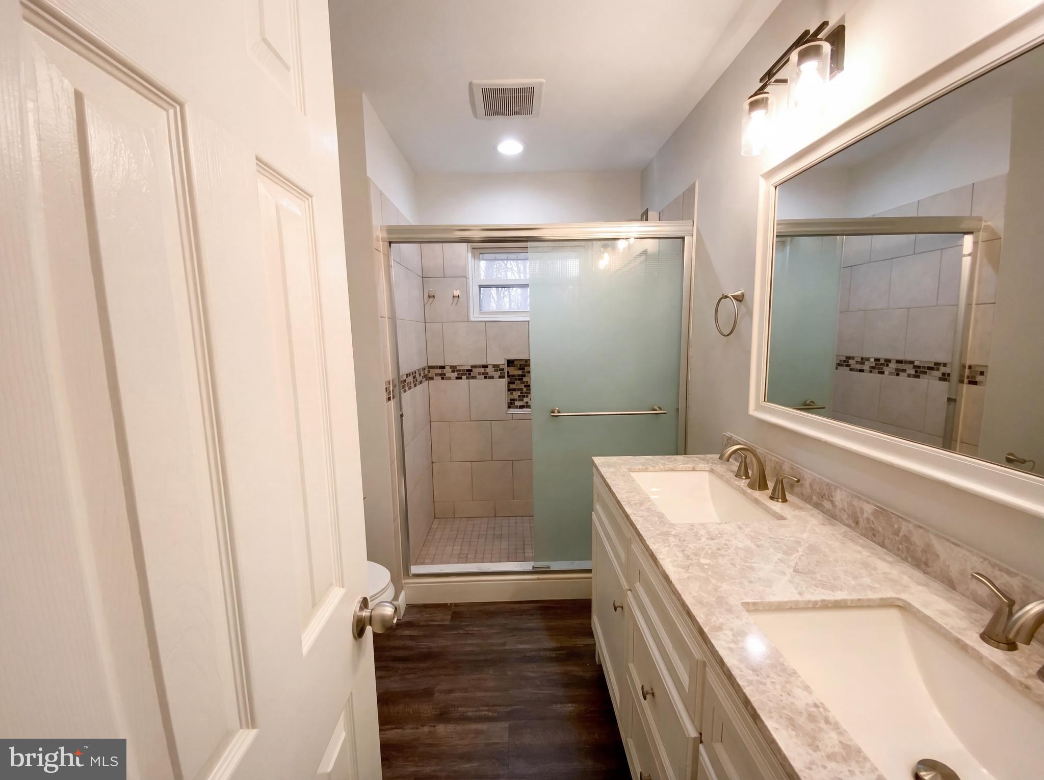 18320 Candice Drive Triangle, VA 22172 - Photo 11 of 19 a bathroom with a granite countertop sink a mirror and shower