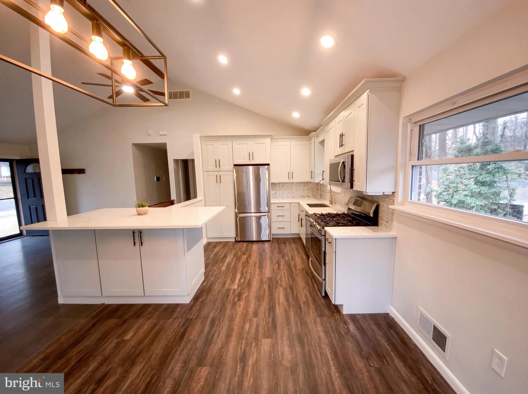 18320 Candice Drive Triangle, VA 22172 - Photo 2 of 19 a kitchen with white cabinets and wooden floor