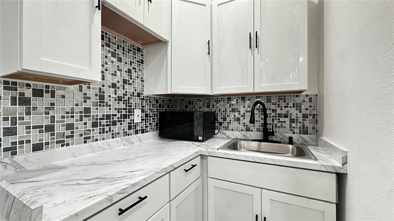 12983 Southwest 229th Lane Miami, FL 33170 - Photo 4 of 9 a kitchen with a sink and cabinets