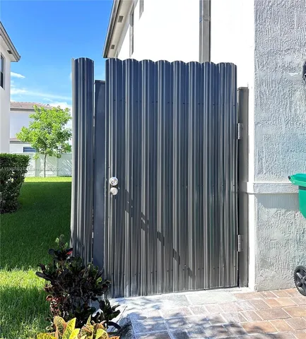 a view of a backyard with potted plants and wooden fence