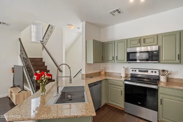 a kitchen with stainless steel appliances kitchen island granite countertop a stove sink and microwave