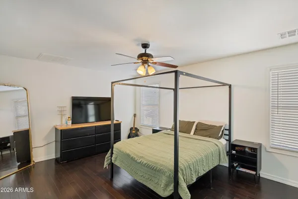 a bedroom with a bed and a flat tv screen on the dresser