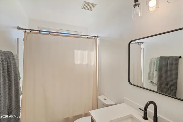 a bathroom with a shower a sink and a mirror