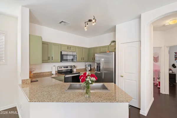 a kitchen with stainless steel appliances granite countertop a refrigerator sink and stove
