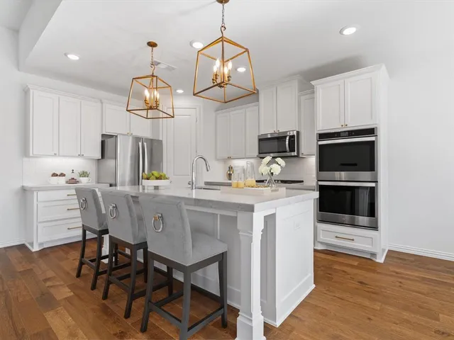 a kitchen with kitchen island white cabinets and stainless steel appliances