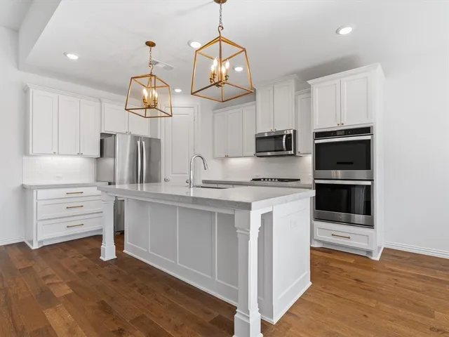 a kitchen with a refrigerator cabinets and wooden floor