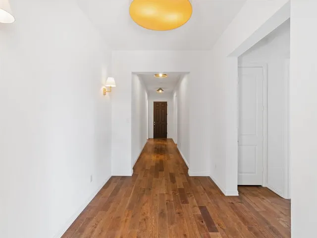 a view of a livingroom with wooden floor and a window