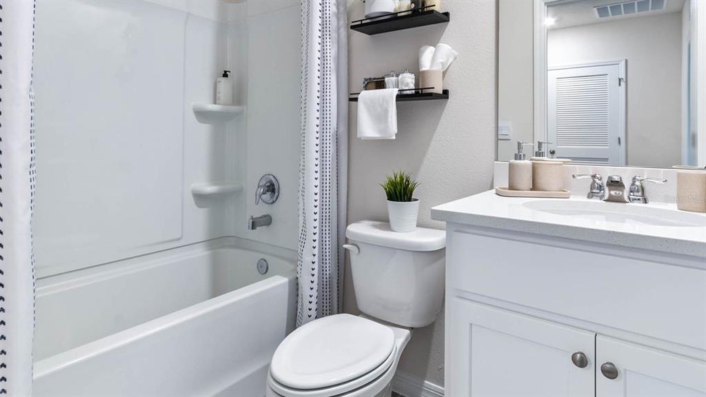 4366 Butterscotch Circle Lakeland, FL 33811 - Photo 24 of 30 a bathroom with a sink a toilet a mirror a vanity and bathtub