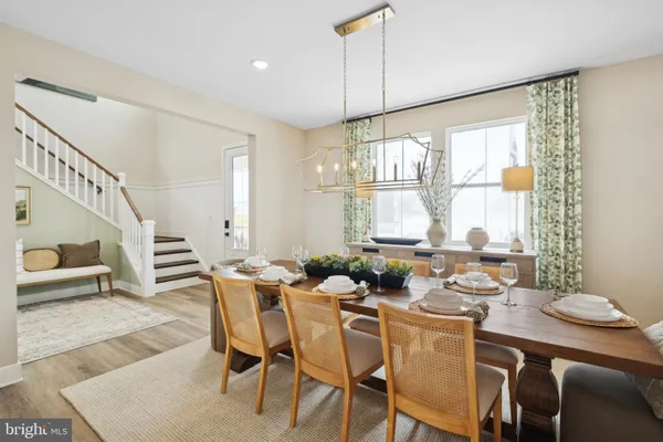 a dining room with furniture a chandelier and wooden floor