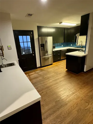 a large kitchen with stainless steel appliances a large counter top
