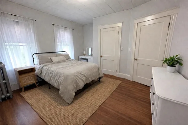 a bedroom with a bed lamp closet and window