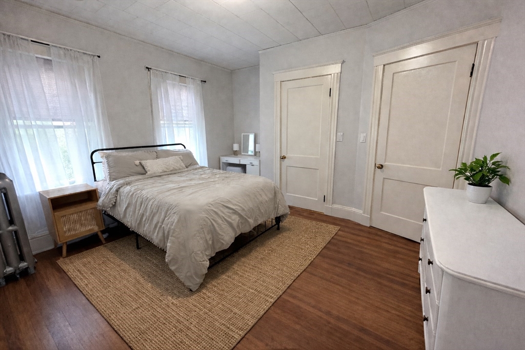 17 Bentley Street, Unit 1 Boston, MA 02135 - Photo 5 of 15 a bedroom with a bed lamp closet and window