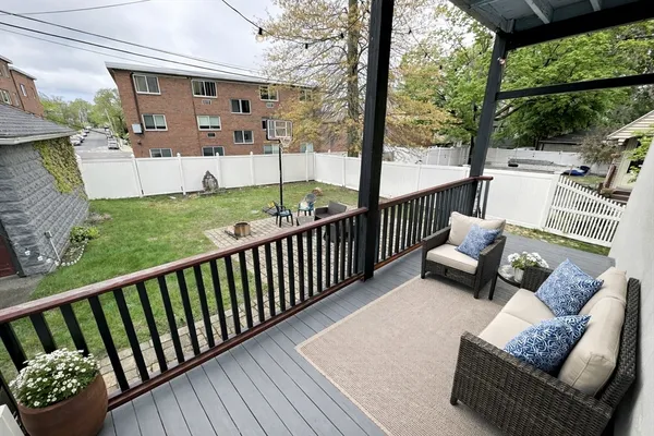 a view of a patio with couches chairs and floor to ceiling window with wooden floor