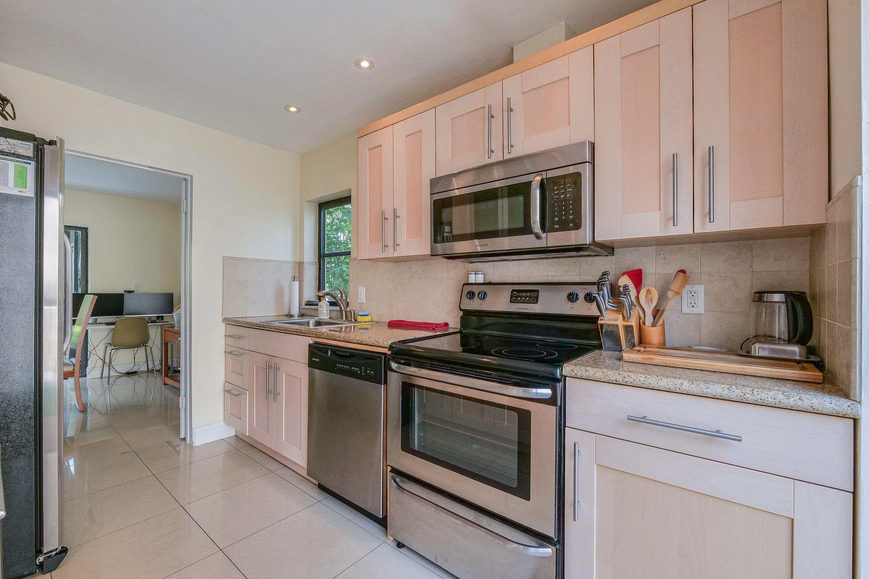 5523 Constant Spring Terrace, Unit 222 Lauderhill, FL 33319 - Photo 12 of 60 a kitchen with stainless steel appliances granite countertop white cabinets a stove a microwave and a sink