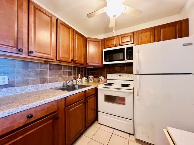 a kitchen with stainless steel appliances granite countertop a sink stove and microwave