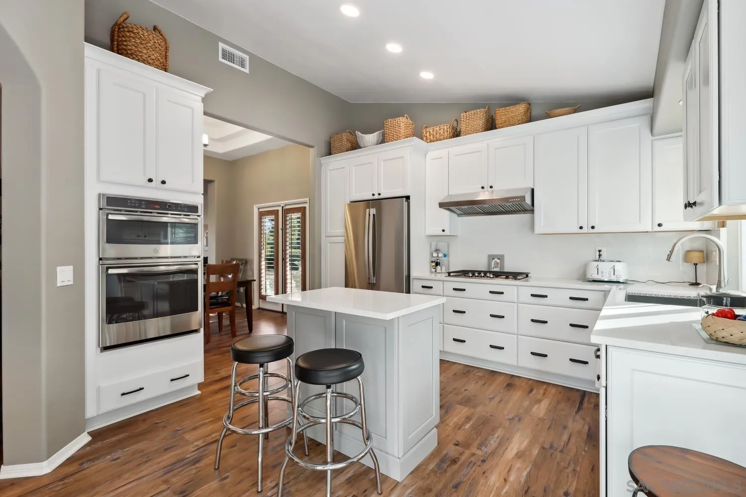 1783 Palomares Road Fallbrook, CA 92028 - Photo 10 of 40 a kitchen with granite countertop a refrigerator oven a sink dishwasher and white cabinets with wooden floor