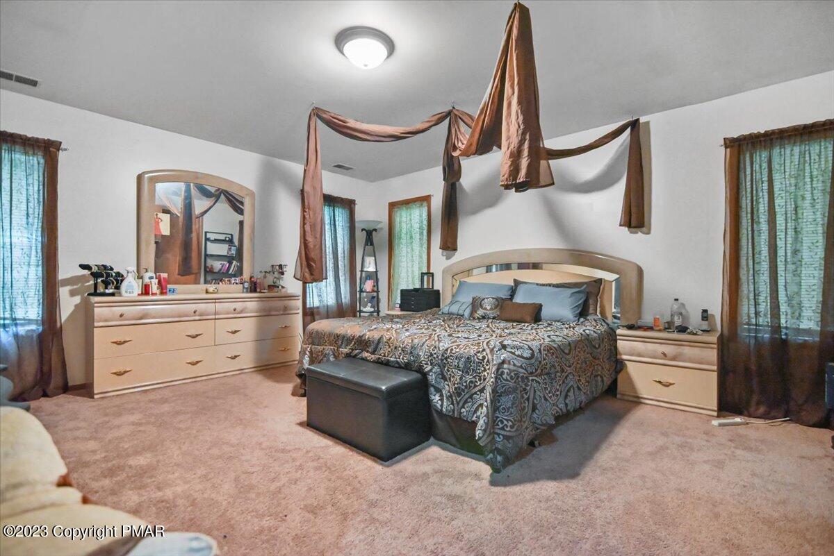 3237 Windemere Drive Bushkill, PA 18324 - Photo 19 of 50 a bedroom with a bed a chandelier and dresser