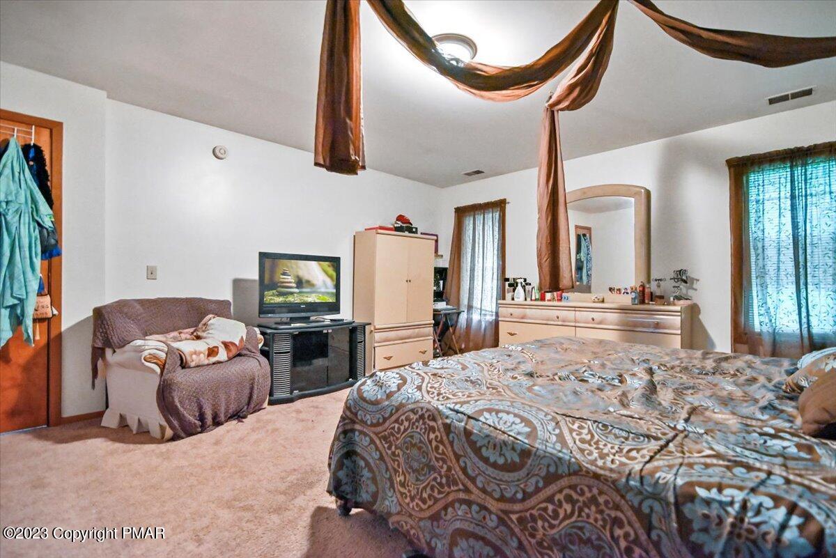 3237 Windemere Drive Bushkill, PA 18324 - Photo 21 of 50 a bedroom with furniture and a mirror