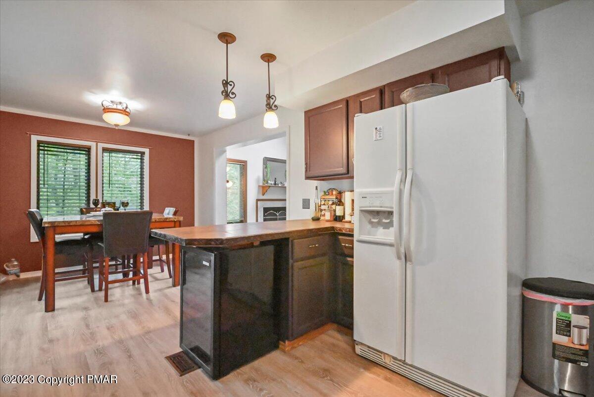 3237 Windemere Drive Bushkill, PA 18324 - Photo 10 of 50 a kitchen with stainless steel appliances a refrigerator a sink dishwasher a dining table and chairs with wooden floor