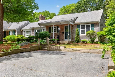 a view of house with outdoor seating area and garden