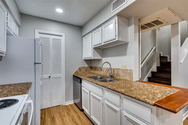 a kitchen with granite countertop a sink and cabinets