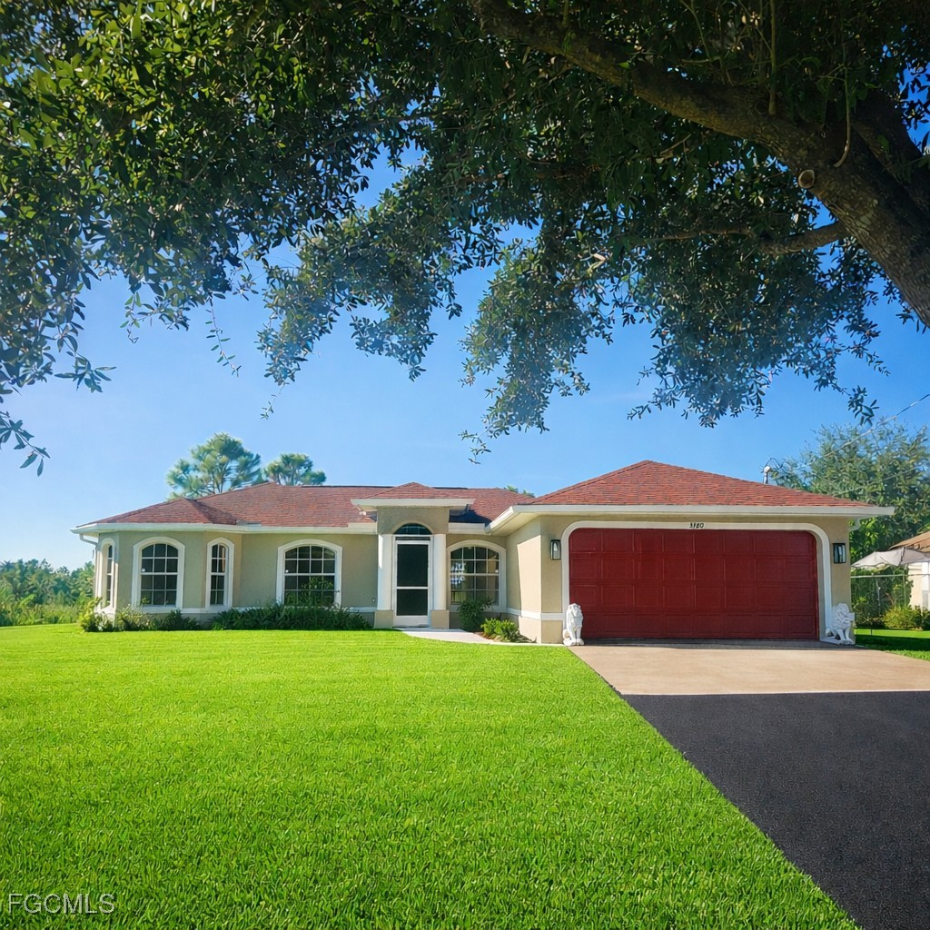 3780 Randall Boulevard Naples, FL 34120 - Photo 2 of 12 a front view of a house with a garden