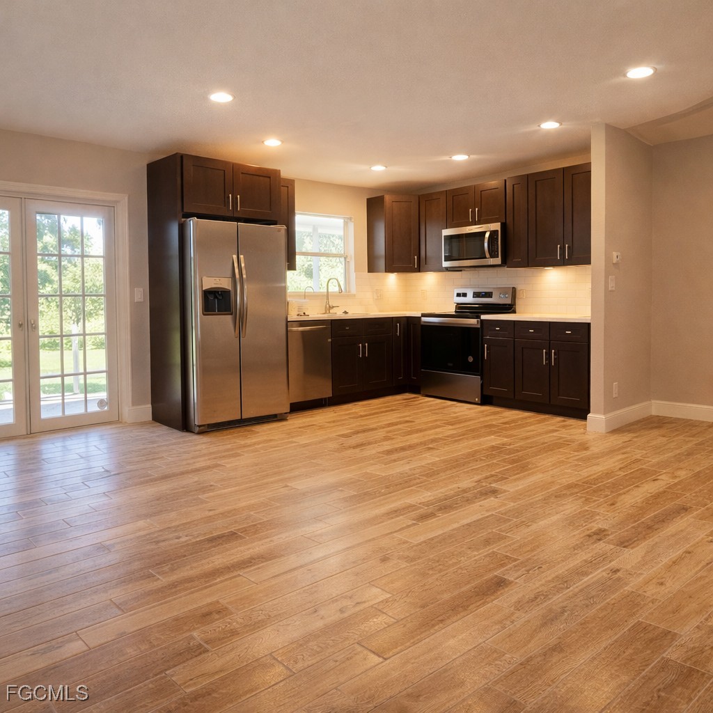 3780 Randall Boulevard Naples, FL 34120 - Photo 4 of 12 a large kitchen with stainless steel appliances granite countertop a large counter top and wooden floors