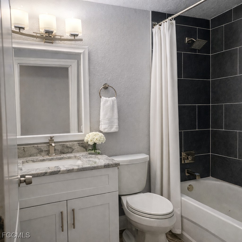 3780 Randall Boulevard Naples, FL 34120 - Photo 7 of 12 a bathroom with a granite countertop toilet a sink and a bathtub