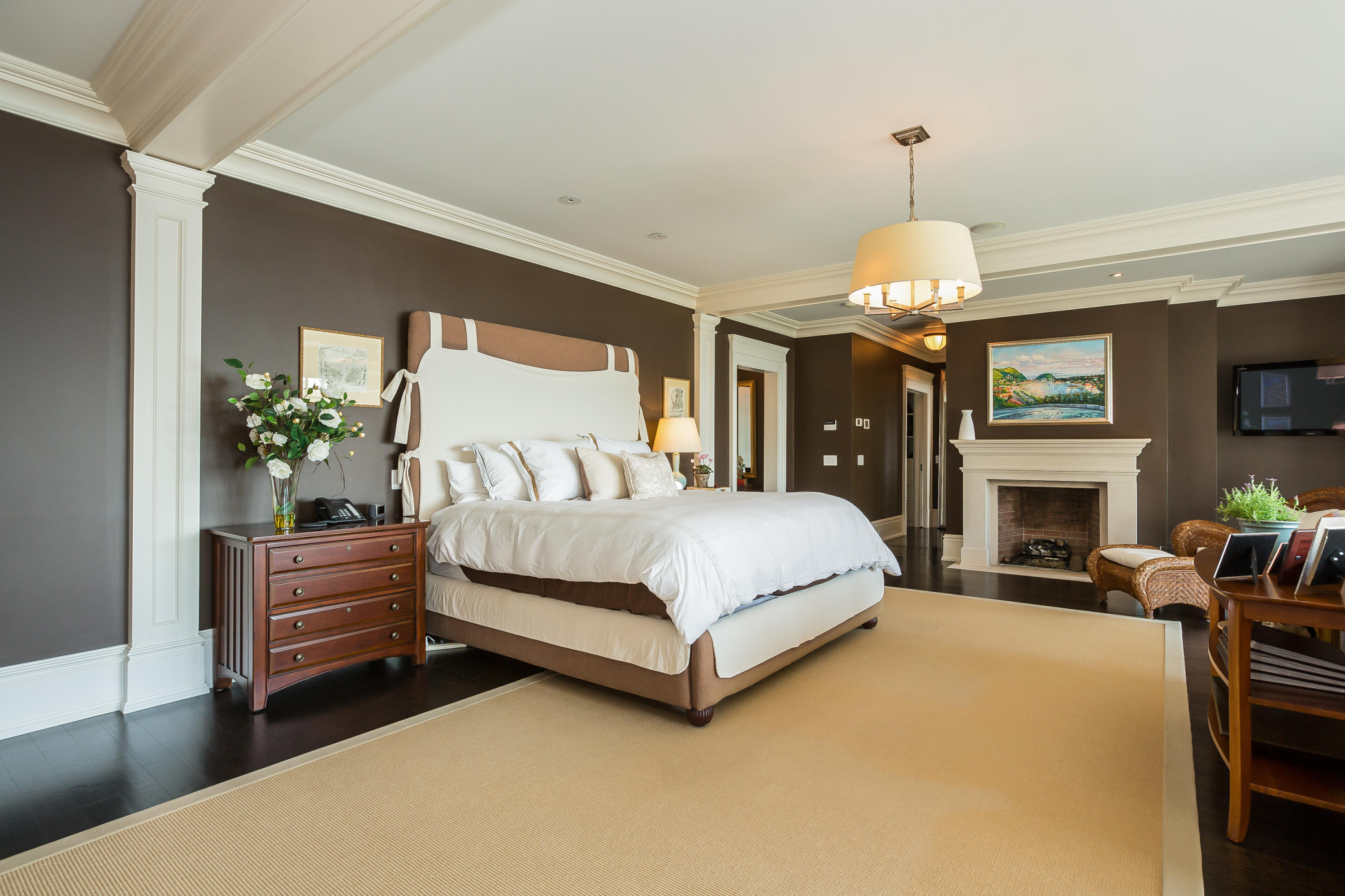 8 N Road Darien, CT 06820 - Photo 34 of 68 a spacious bedroom with a bed chandelier and fireplace
