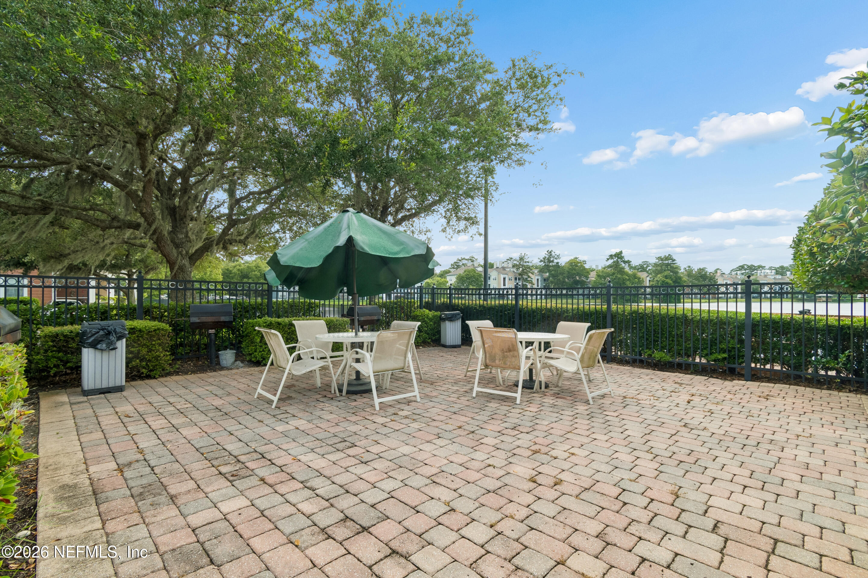 8550 Touchton Road, Unit 511 Jacksonville, FL 32216 - Photo 46 of 63 a view of a patio with table and chairs potted plants and a large tree
