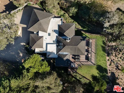 an aerial view of a house with a yard and trees